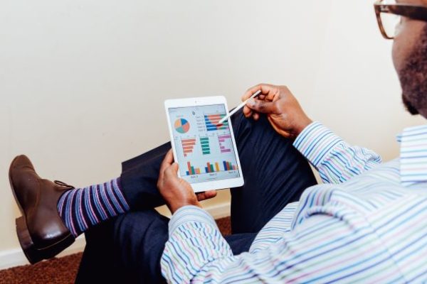 man siting and holding an ipad on his hands