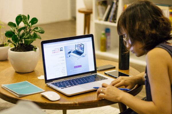 woman using smartphone with laptop on the table